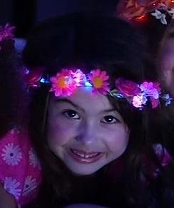 Mia® Beauty Flashion Flowers - LED Lighted Headband - Pink daisies on model from commerical